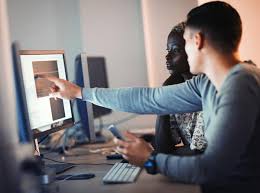Two people working on computers in an office.