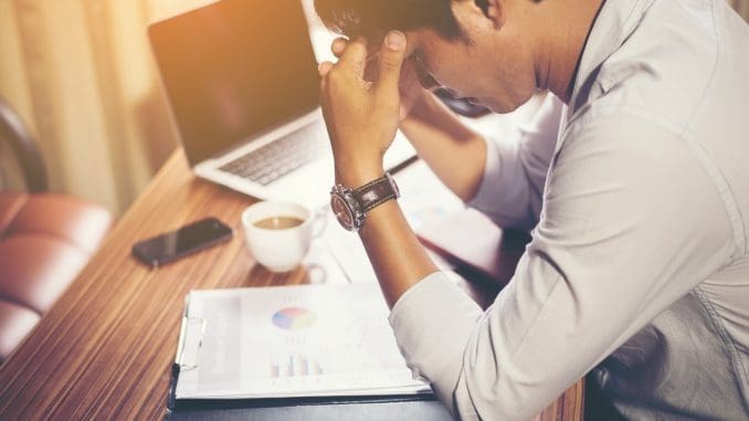 Employee l4ooking at a statistical report and looking stressed