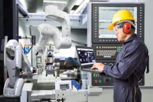 Engineer working on a machine and analysing data in Laptop